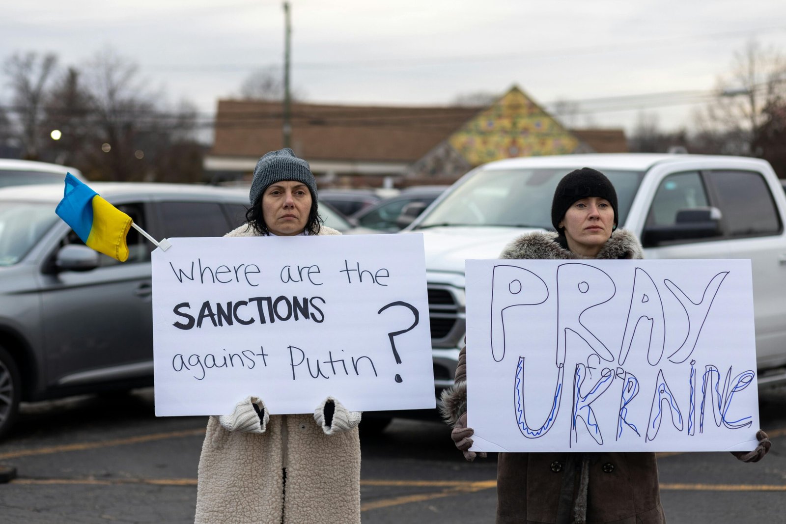 Women holding protest signs in support of Ukraine, expressing political messages and solidarity. Outdoors.