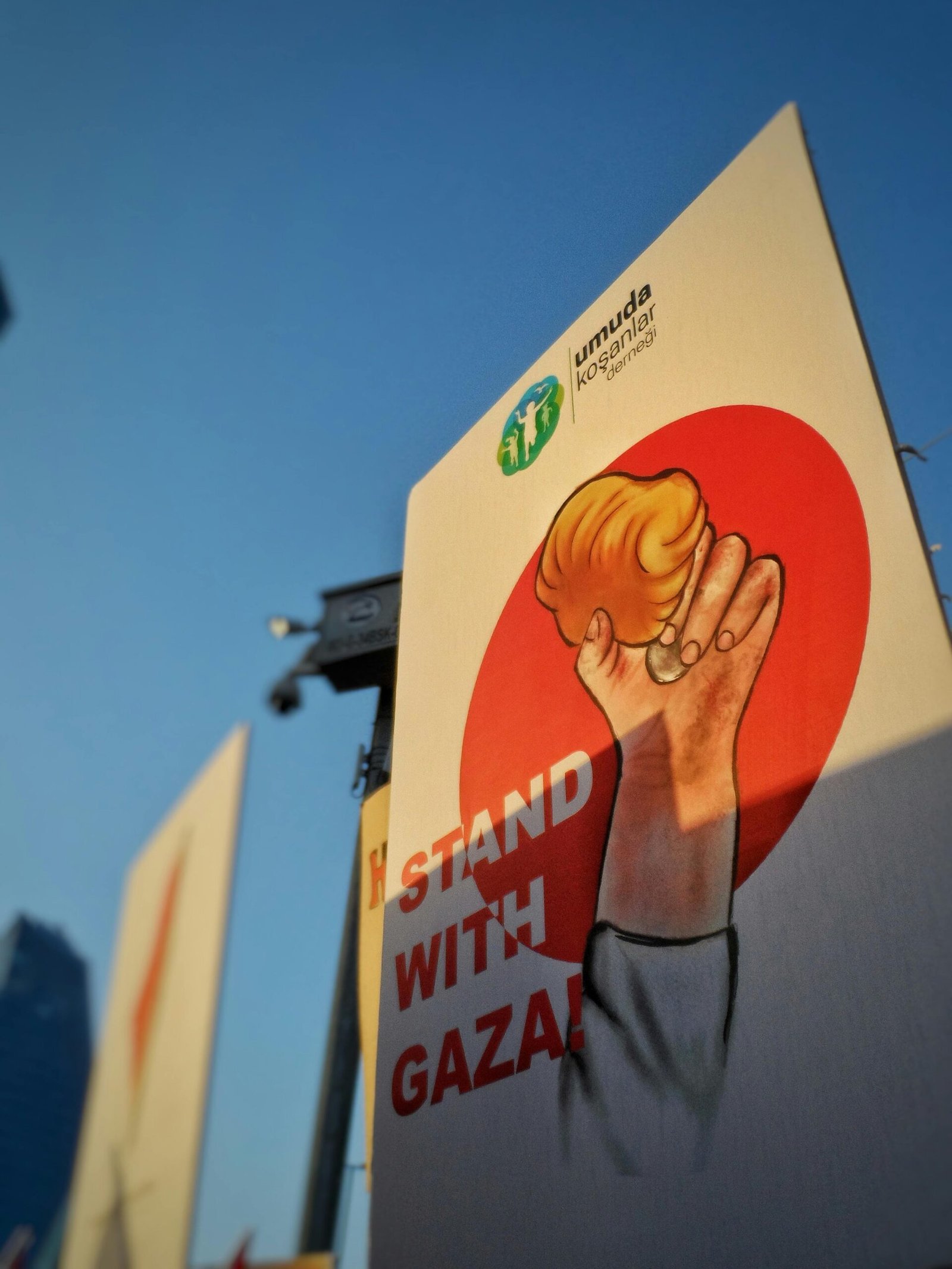 A striking protest banner with 'Stand With Gaza' message held in a public demonstration.